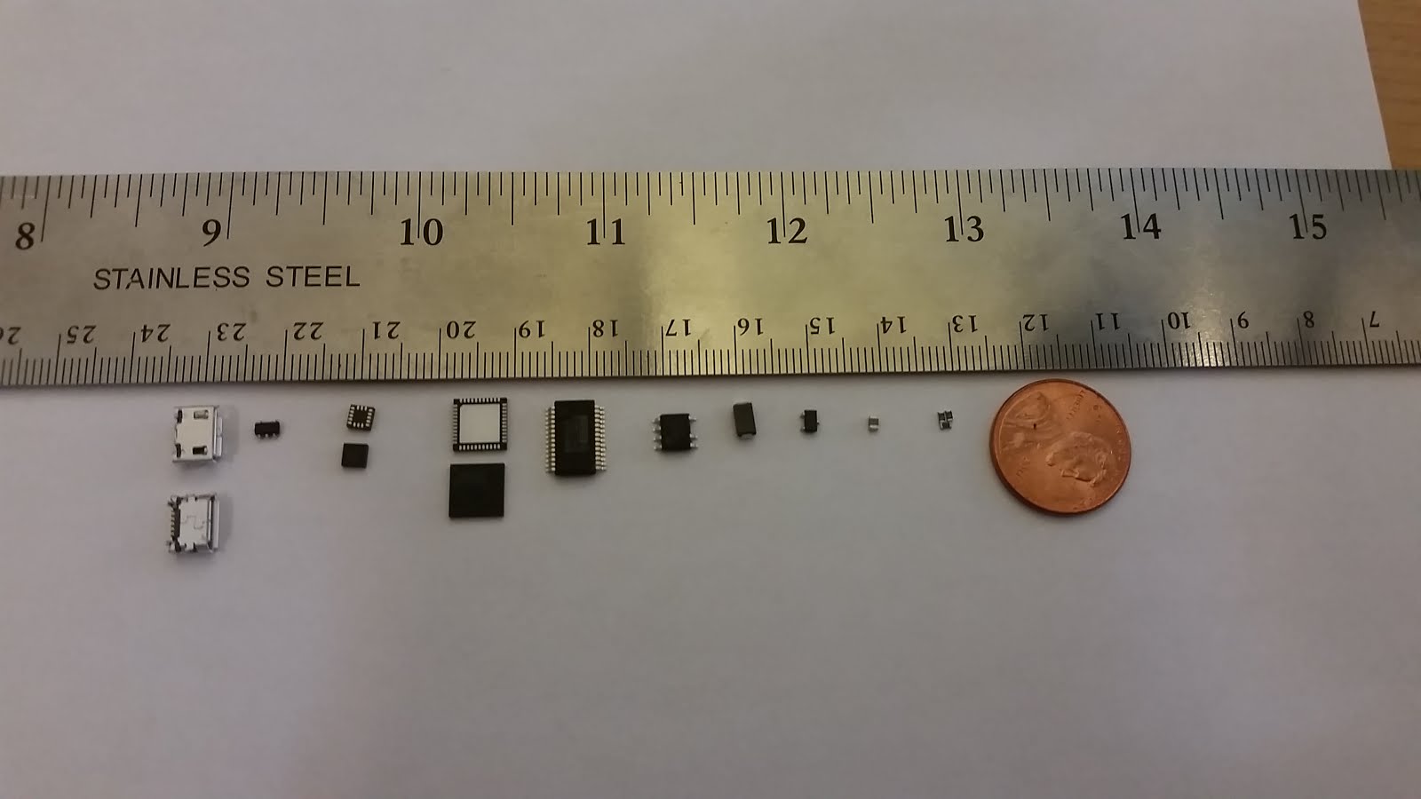 Surface mount parts are tiny, this comparison shows a handful of parts compared to a ruler and a penny